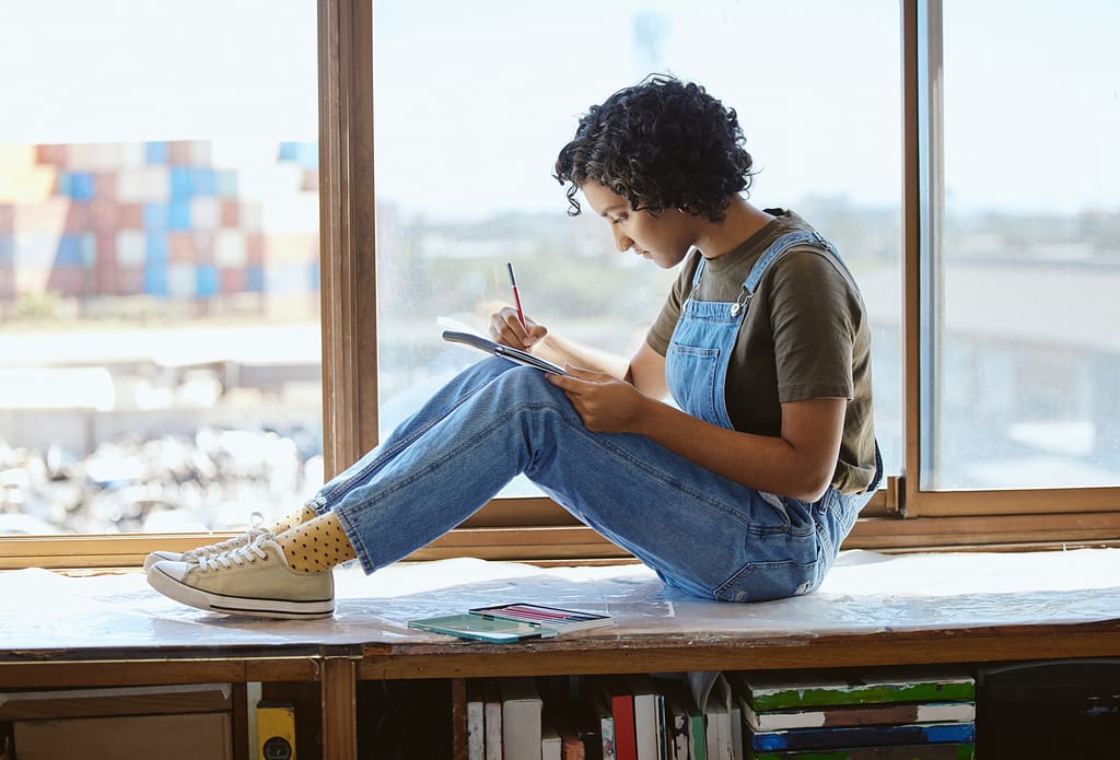 Art student, creative or woman drawing by window in artistic studio, planning innovation painting .